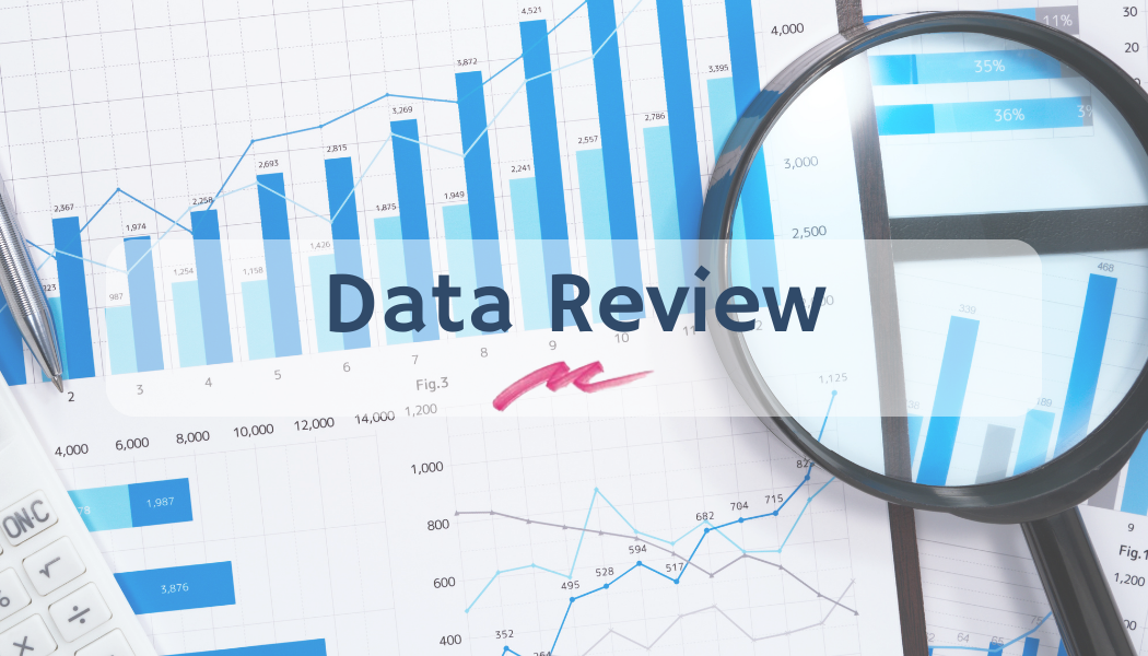 a close up of graphs and charts with a magnifying glass and the words data review overlayed