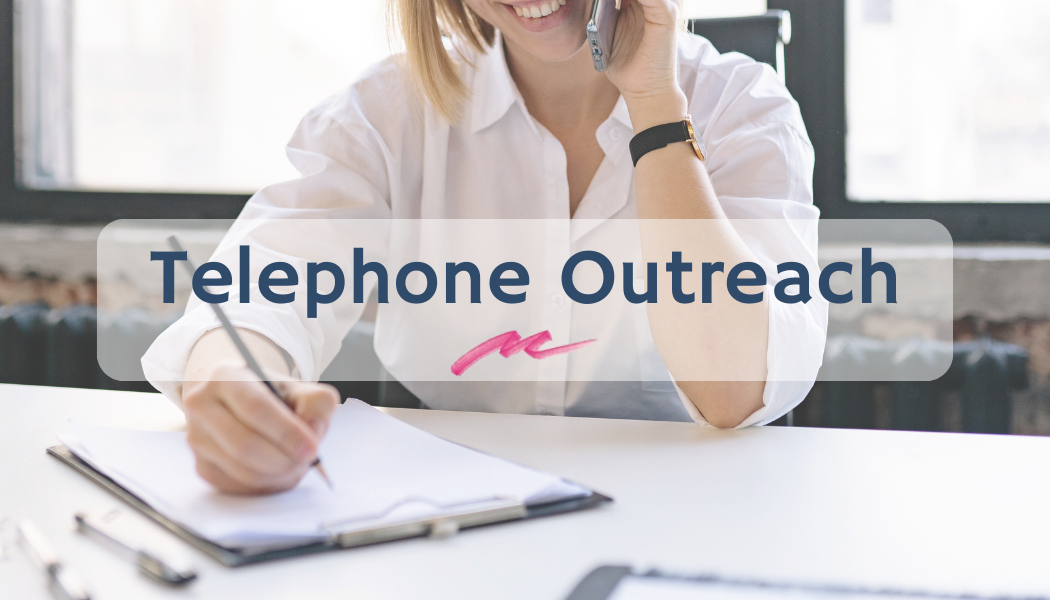 A woman in a white button down shirt on a cell phone writing on a clipboard with the words telephone outreach overlayed